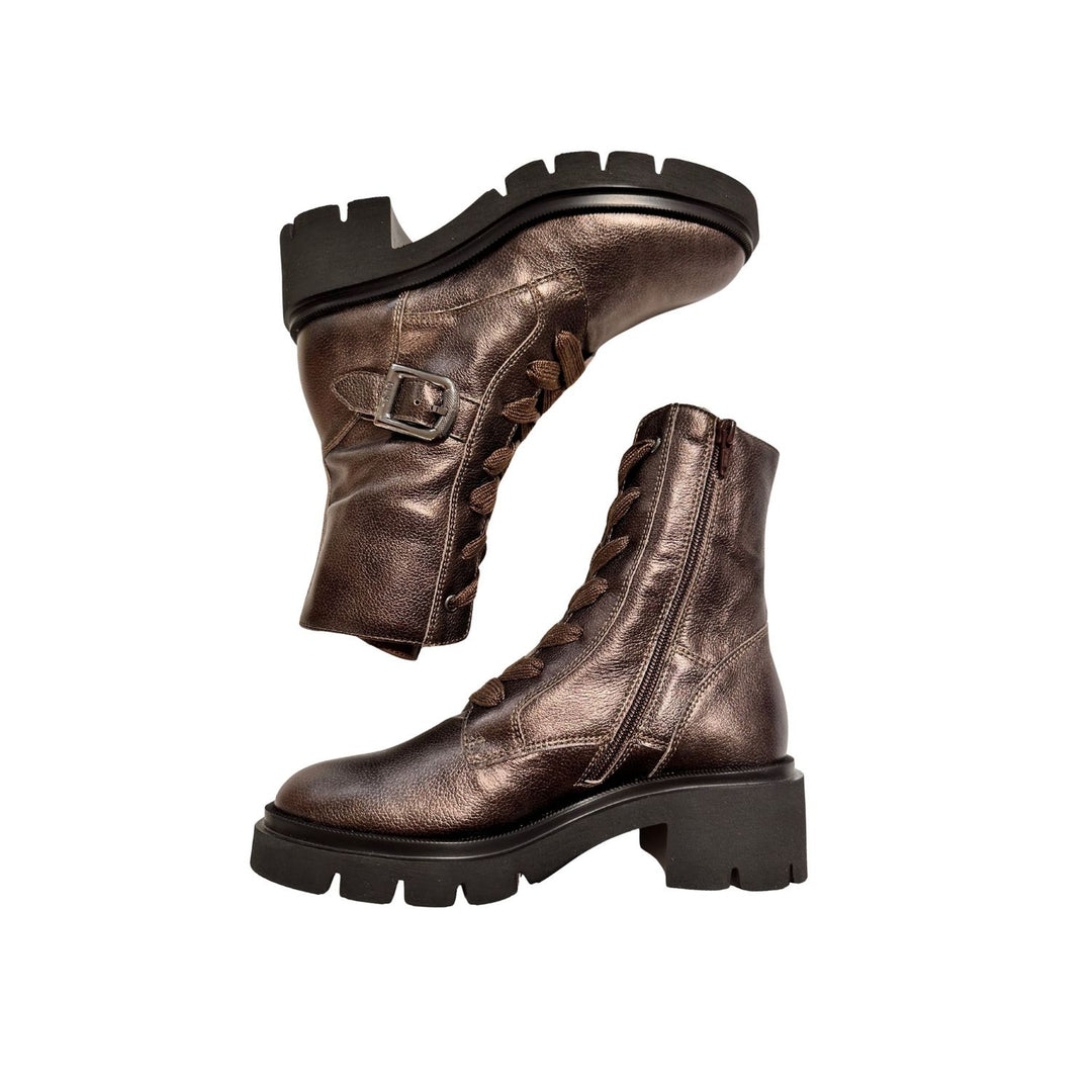 Pair of bronze leather boots with black soles on a white background