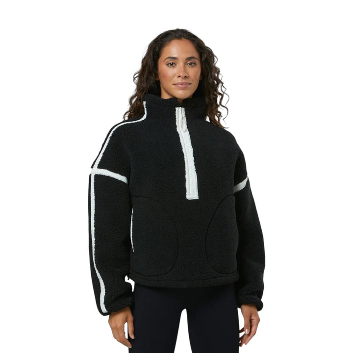 Woman wearing a black fleece pullover with white stripes on a white background