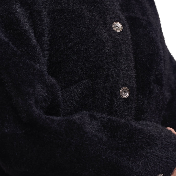 Close-up of a dark coat with buttons on a white background