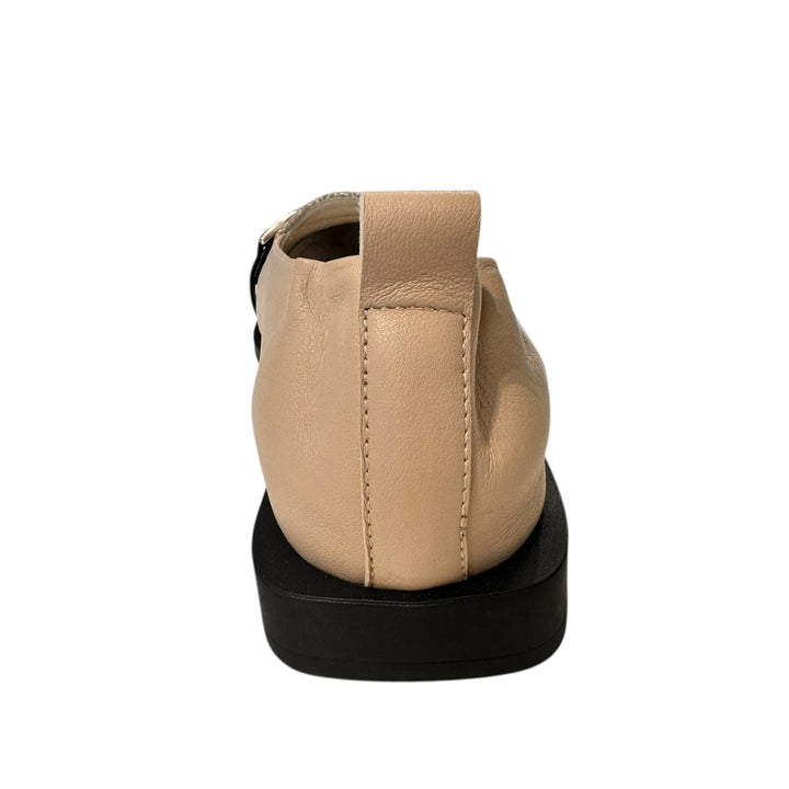 Beige shoe with a black sole on a white background
