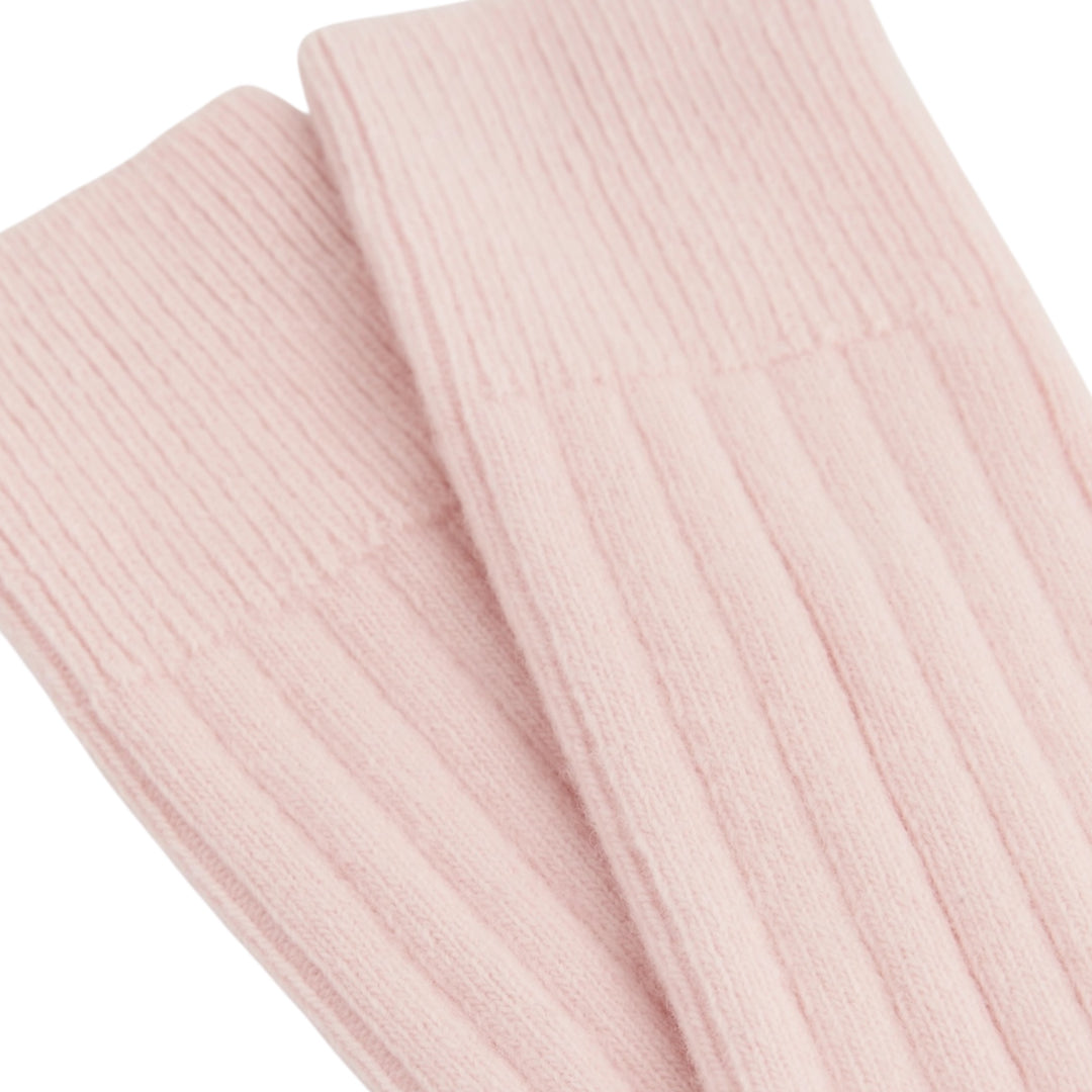 A close-up of a pair of light pink ribbed bed socks on a plain white background.