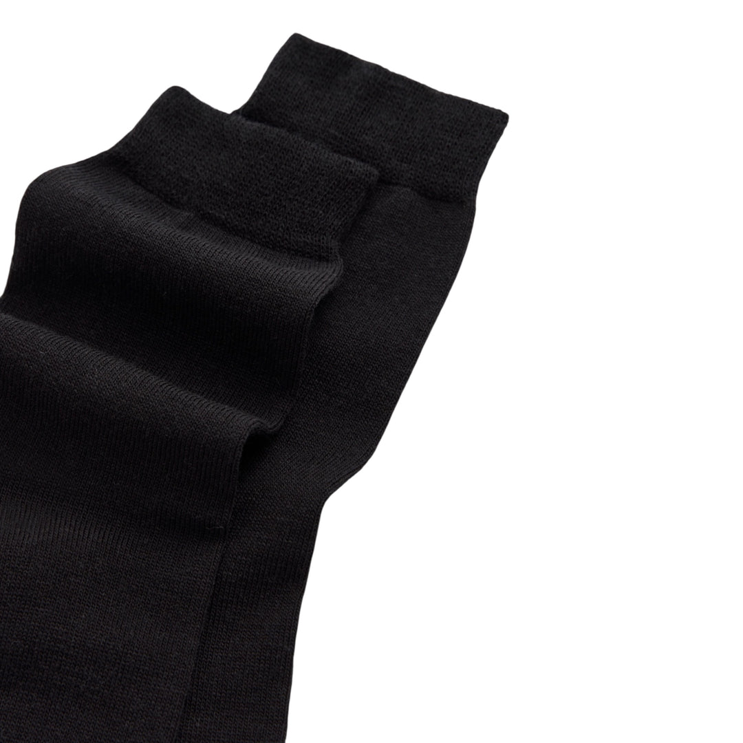 A close-up of a black ribbed knit sock or pant leg folded diagonally on a plain white background.