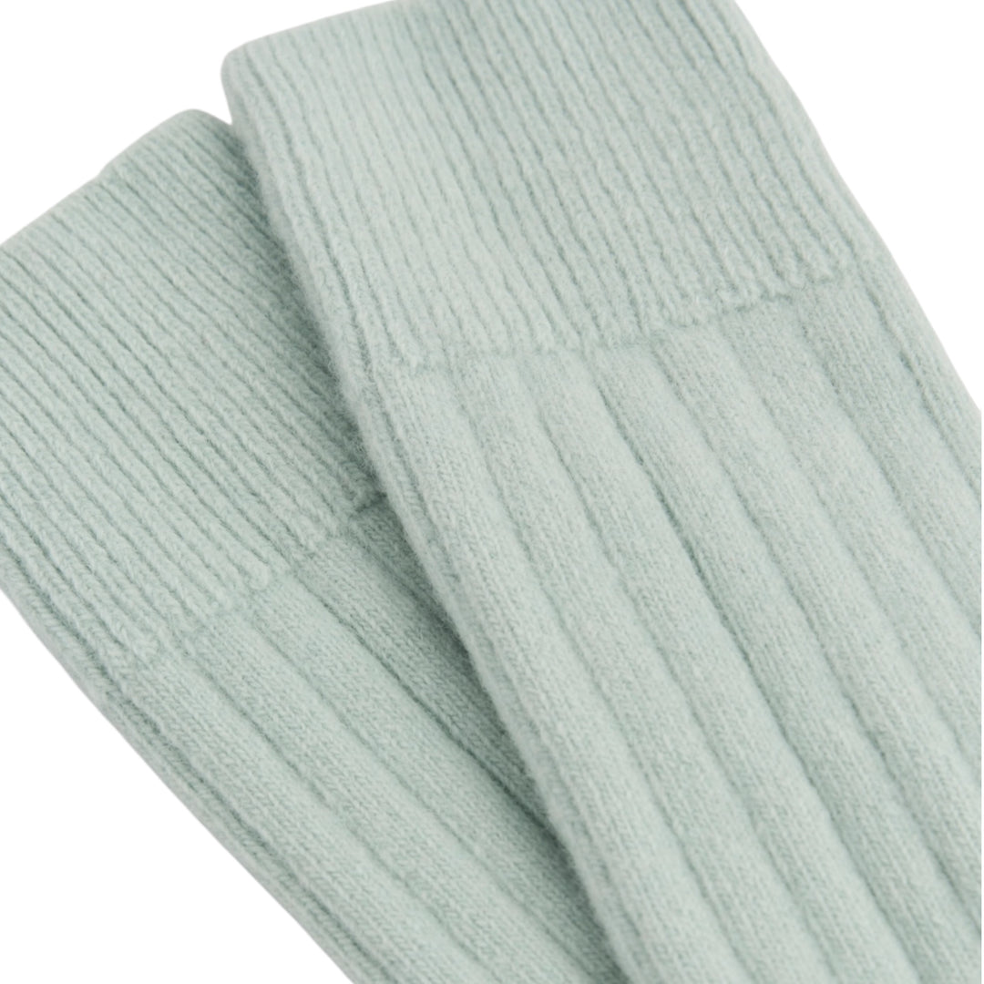A close-up of ribbed knit socks in a pale mint green color, showing the texture and cuff detail against a plain white background.