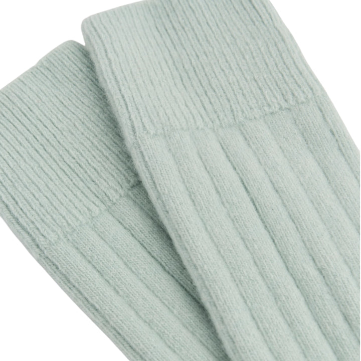 A close-up of ribbed knit socks in a pale mint green color, showing the texture and cuff detail against a plain white background.