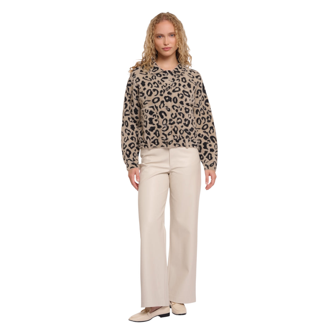 Woman wearing a leopard print sweater and beige pants on a white background