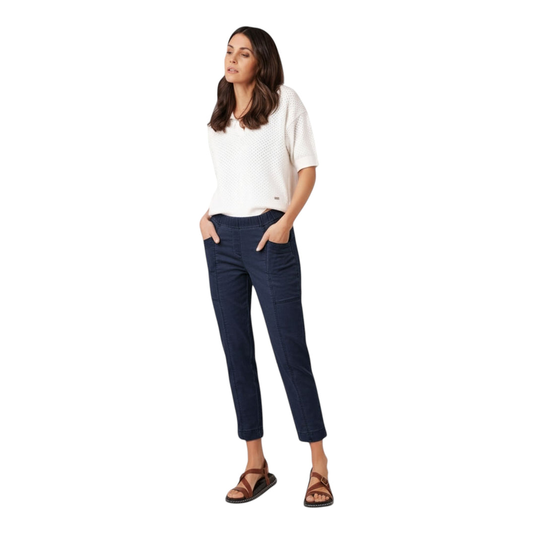 Woman wearing navy pants and a white top on a white background